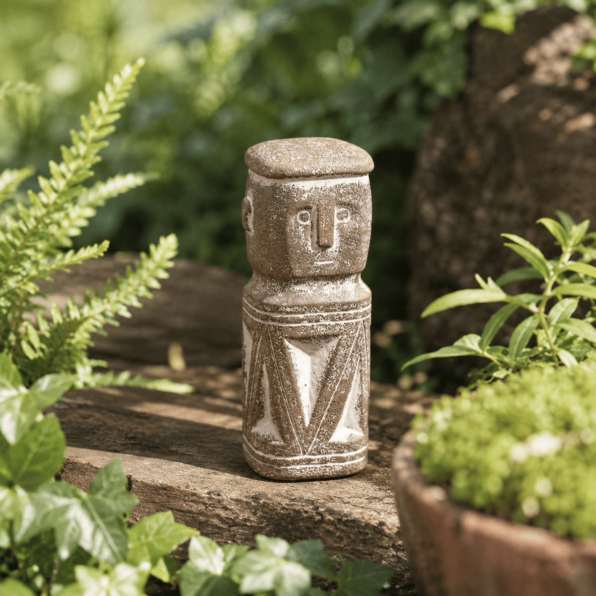 A tall garden figure beside a planted pot