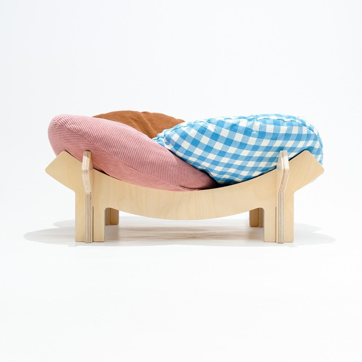 Brown birch wood cat bed with gingham cushion and natural wood frame